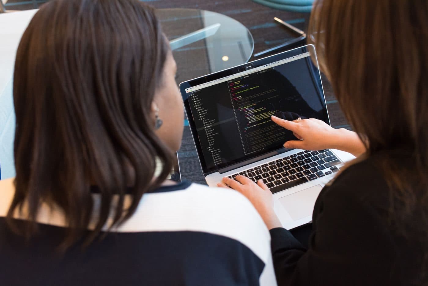 Two developers pair programming on a laptop